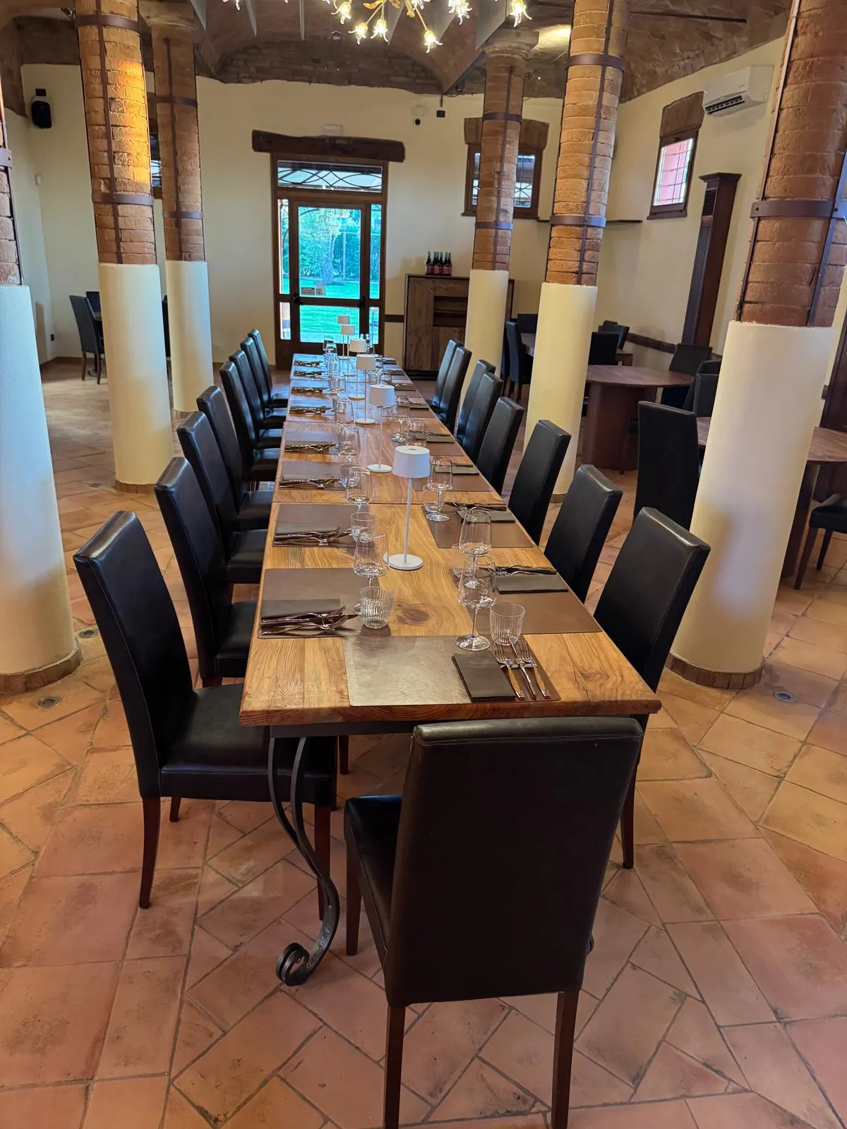 La sala del ristorante Il Gattopardo con colonne in mattone e tavolo imperiale apparecchiato