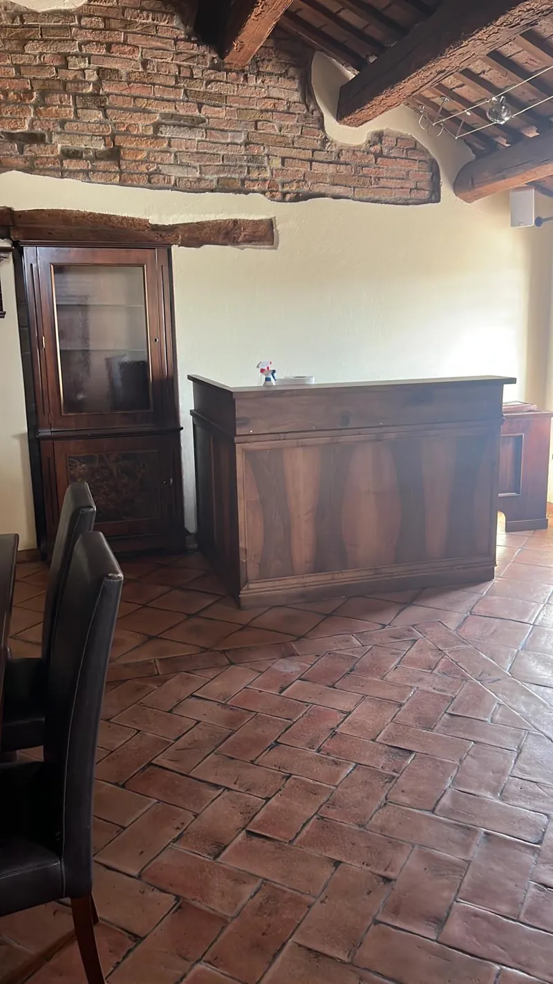 Il bancone in legno scuro del soppalco, sotto il tetto a travi
