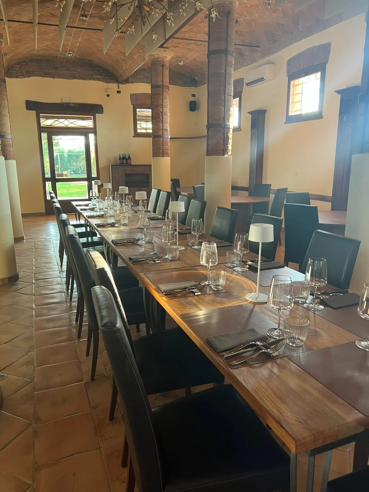 Un tavolo apparecchiato davanti alla parete in mattoni del ristorante